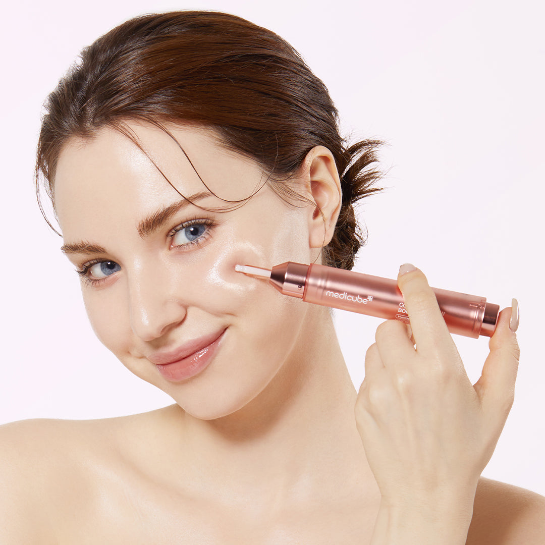 Woman holding a cosmetic pen near her face on a light background